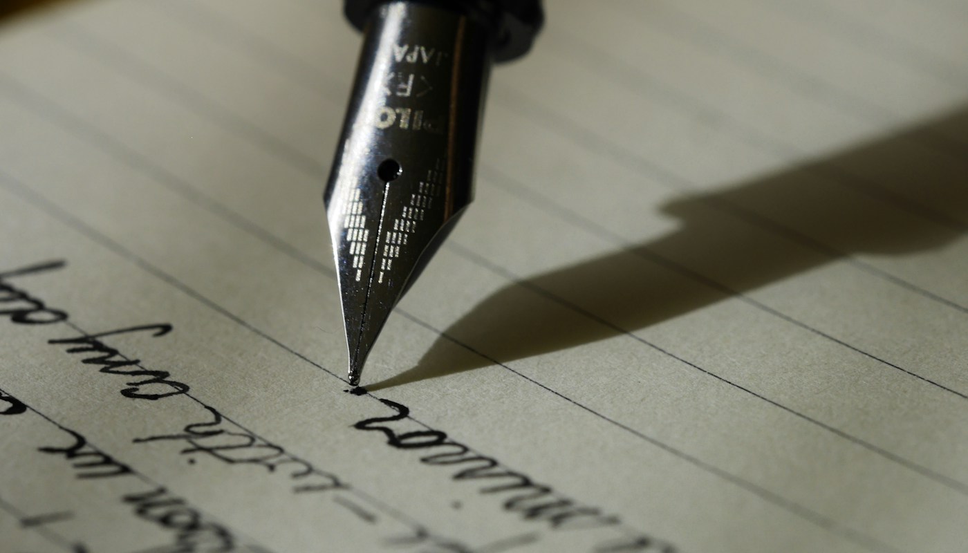 Libreta de trabajo y pluma sobre un escritorio, una pausa para poner en palabras